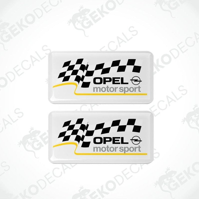 Two white vinyl stickers with checkered patterns and the text 'OPEL MOTORSPORT' printed on them.