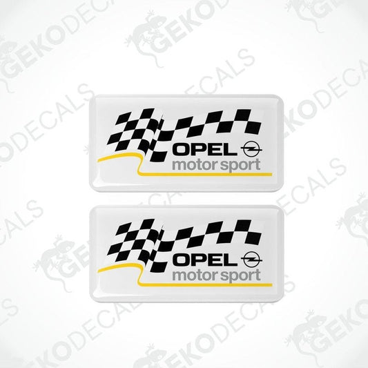 Two white vinyl stickers with checkered patterns and the text 'OPEL MOTORSPORT' printed on them.