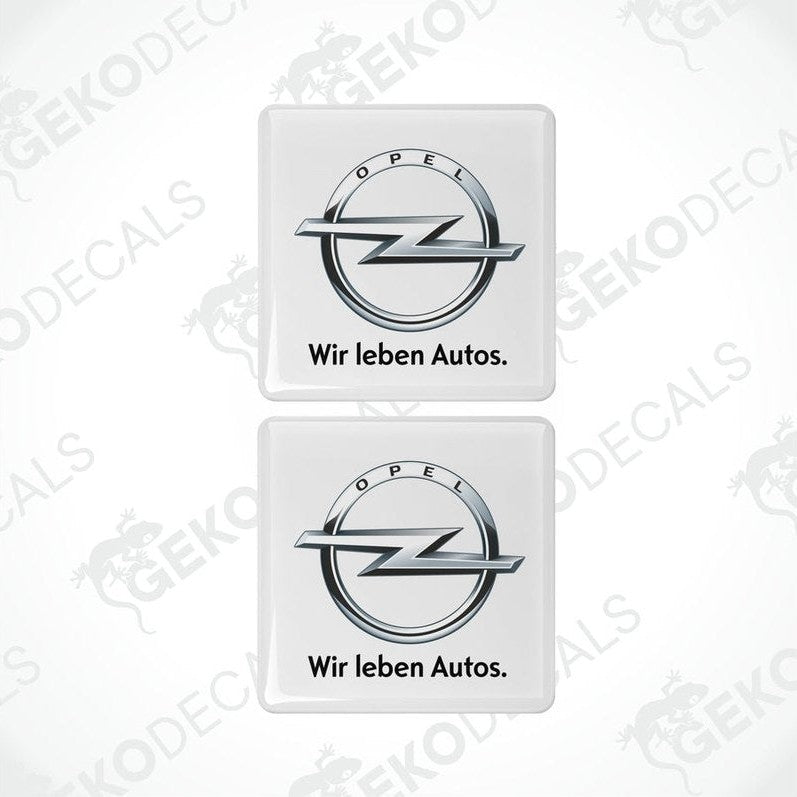 Two withe vinyl stickers with the Opel brand logo and the text 'WIR LEBEN AUTOS'.