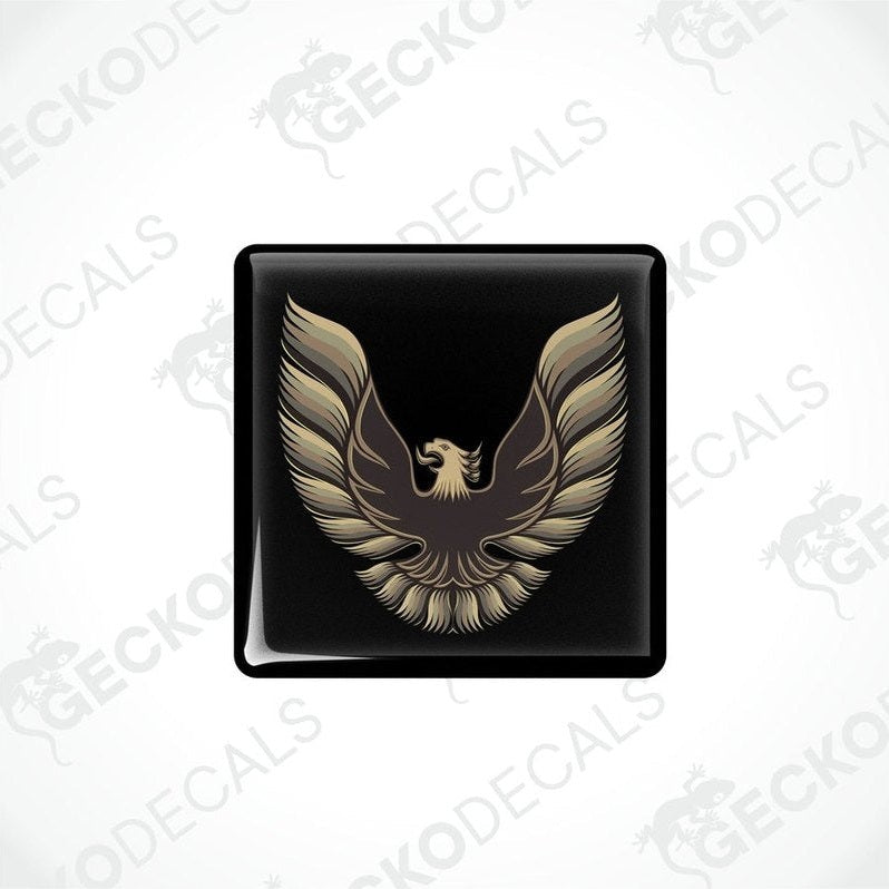 Black vinyl stickers with a gold and bronze emblem design, placed against a white background.