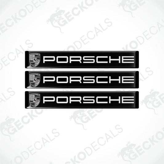 Three black vinyl stickers with the Porsche brand logo in white.