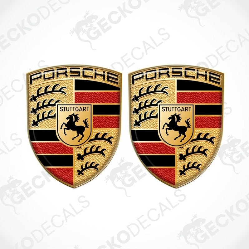 Two 3D dome-shaped decals with Porsche logo and Stuttgart emblem, predominantly in black, red, and yellow colors.