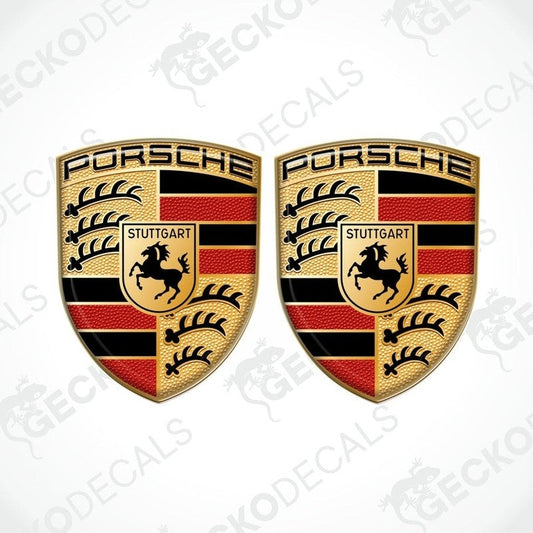 Two 3D dome-shaped decals with Porsche logo and Stuttgart emblem, predominantly in black, red, and yellow colors.