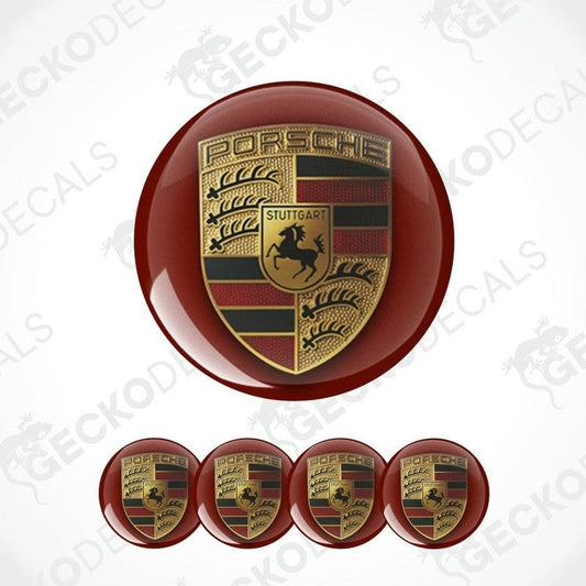 three-dimensional metallic gold Porsche logo on a dark burgundy circular background