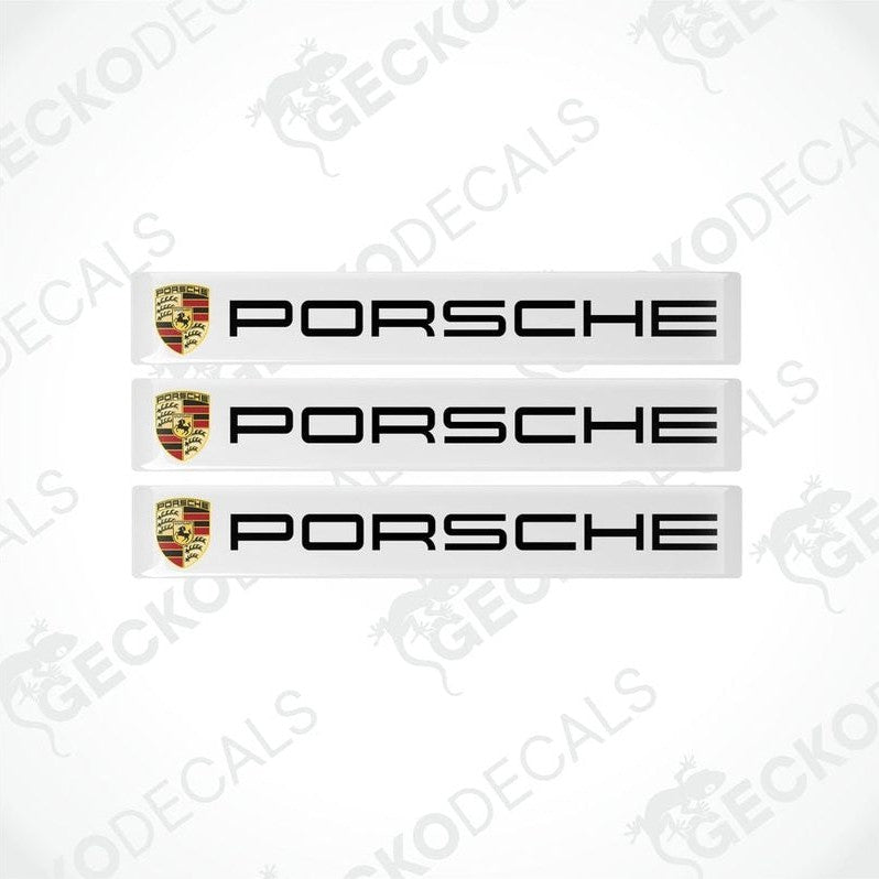 Three withe vinyl stickers with the Porsche brand logo on each.