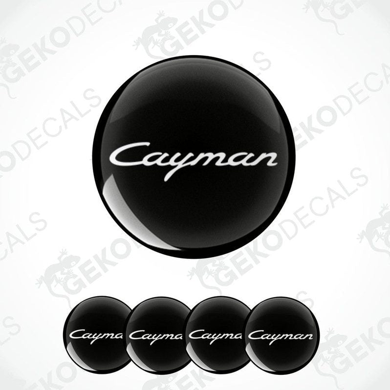 A set of four black vinyl stickers with the word 'CAYMAN' written on them, arranged in a stacked fashion with the top sticker being the largest and the others progressively smaller.