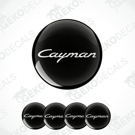 A set of four black vinyl stickers with the word 'CAYMAN' written on them, arranged in a stacked fashion with the top sticker being the largest and the others progressively smaller.