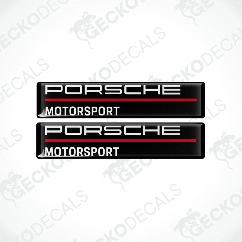 Two rectangular black vinyl decals with 'PORSCHE MOTORSPORT' text in white and red.