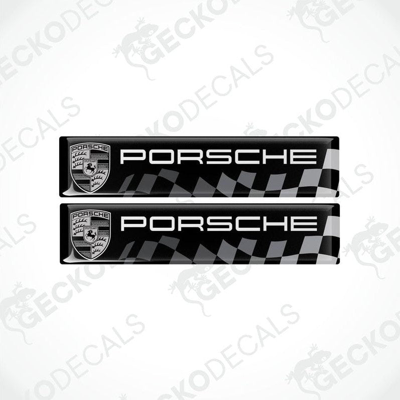 Two black vinyl stickers with the Porsche racing logo and a checkered pattern.