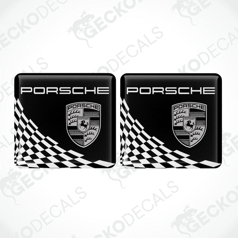 Two black, white, and gold Porsche branded vinyl stickers with a checkered pattern.