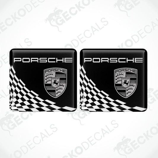 Two black, white, and gold Porsche branded vinyl stickers with a checkered pattern.