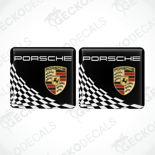 Two black, white, and gold Porsche branded vinyl stickers with a checkered pattern.