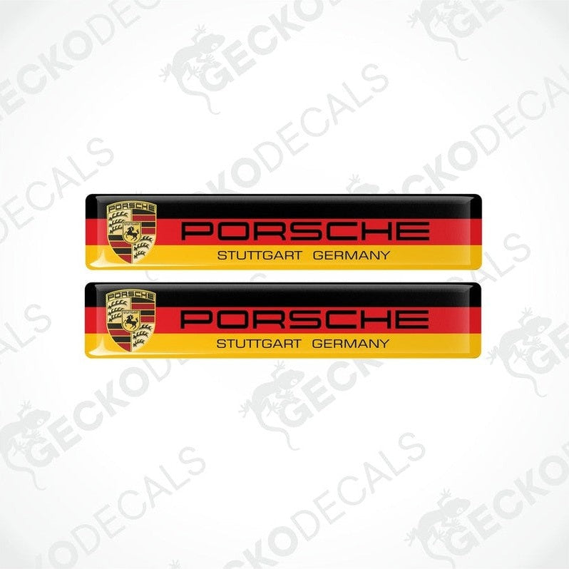 Two rectangular car decals with the Porsche Stuttgart Germany text and the Porsche logo, predominantly in red, yellow, black, and white colors.