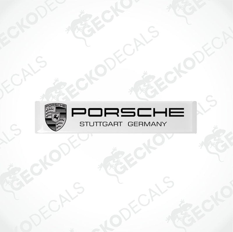 Withe rectangular vinyl decals with the text 'PORSCHE STUTTGART GERMANY' on them, placed on a black background.