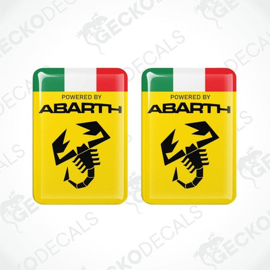 Two yellow vinyl stickers with 'POWERED BY ABARTH' text and a graphic of a black and white checkered flag with a red and green stripe on top. Gecko Decals branding is visible on the stickers.