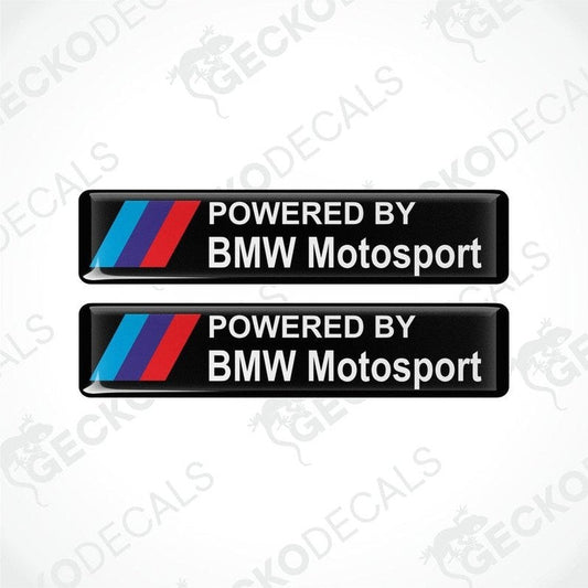 Two black vinyl stickers with the text 'POWERED BY BMW MOTOSPORT' and the BMW logo in red, white, and purple.