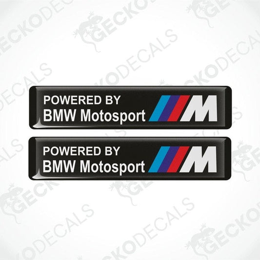 Two black vinyl stickers with the text 'POWERED BY BMW MOTOSPORT M' and the BMW logo in white, red, and blue colors.