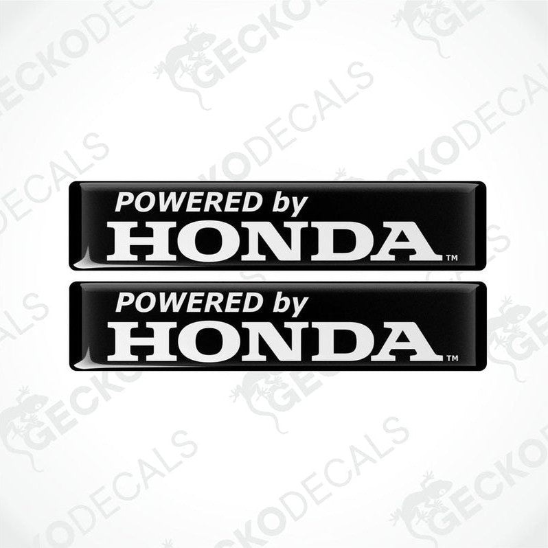 Two black vinyl decals with white text 'POWERED by HONDA' on a textured background.