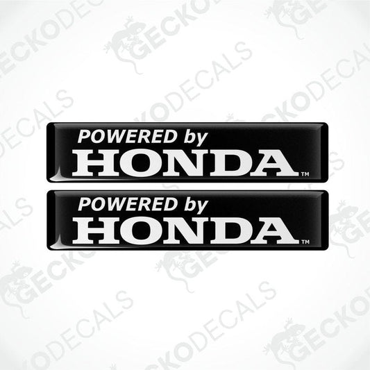 Two black vinyl decals with white text 'POWERED by HONDA' on a textured background.