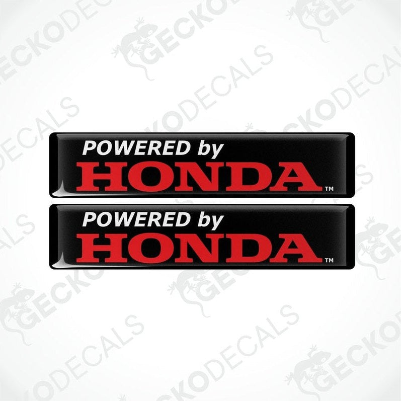 Two black vinyl stickers with the text 'POWERED BY HONDA' in red and white.