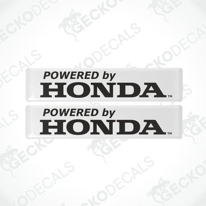 Two white vinyl decals with black text 'POWERED by HONDA' on a textured background.