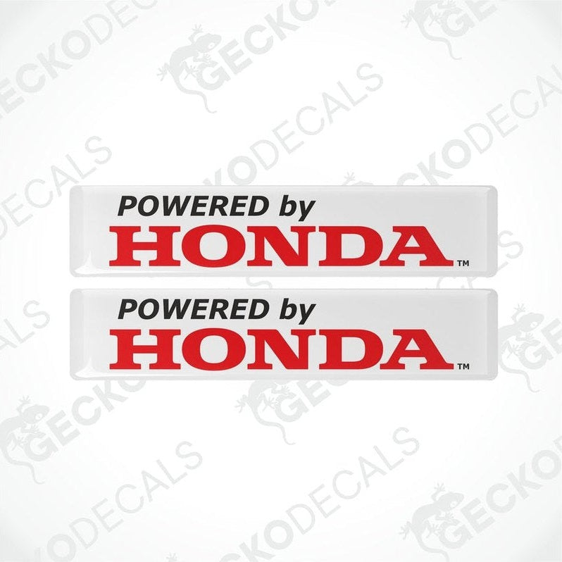 Two white vinyl stickers with the text 'POWERED BY HONDA' in red and black.