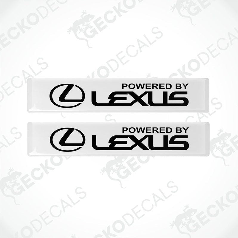 Two white rectangular car decals with the black text 'POWERED BY LEXUS' on the front.