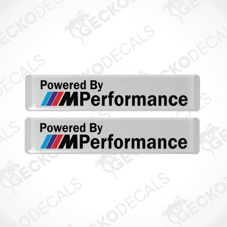 Two white vinyl stickers with the text 'POWERED BY M PERFORMANCE' and the BMW logo.