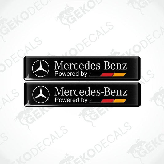 Two black vinyl decals with the 'Mercedes-Benz Powered by' text in white and red-yellow accents.