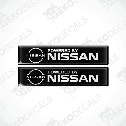 Two black vinyl stickers with 'Powered by NISSAN' text and a white circular logo of NISSAN in the center.