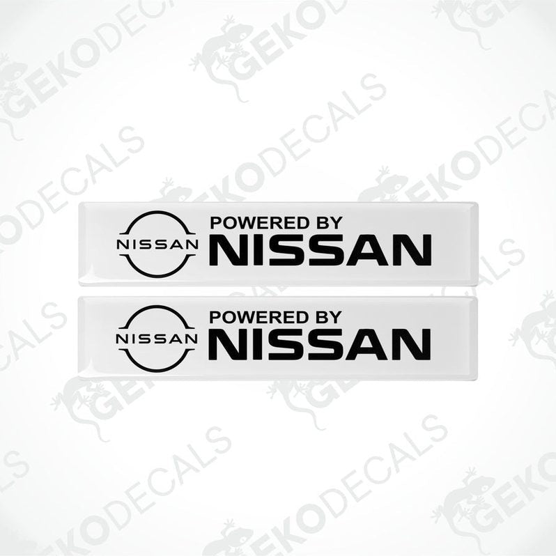 Two white vinyl stickers with 'Powered by NISSAN' text and a black circular logo of NISSAN in the center.