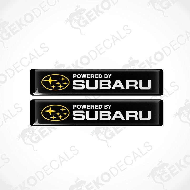Two black vinyl stickers with the text 'POWERED BY SUBARU' and the Subaru logo.