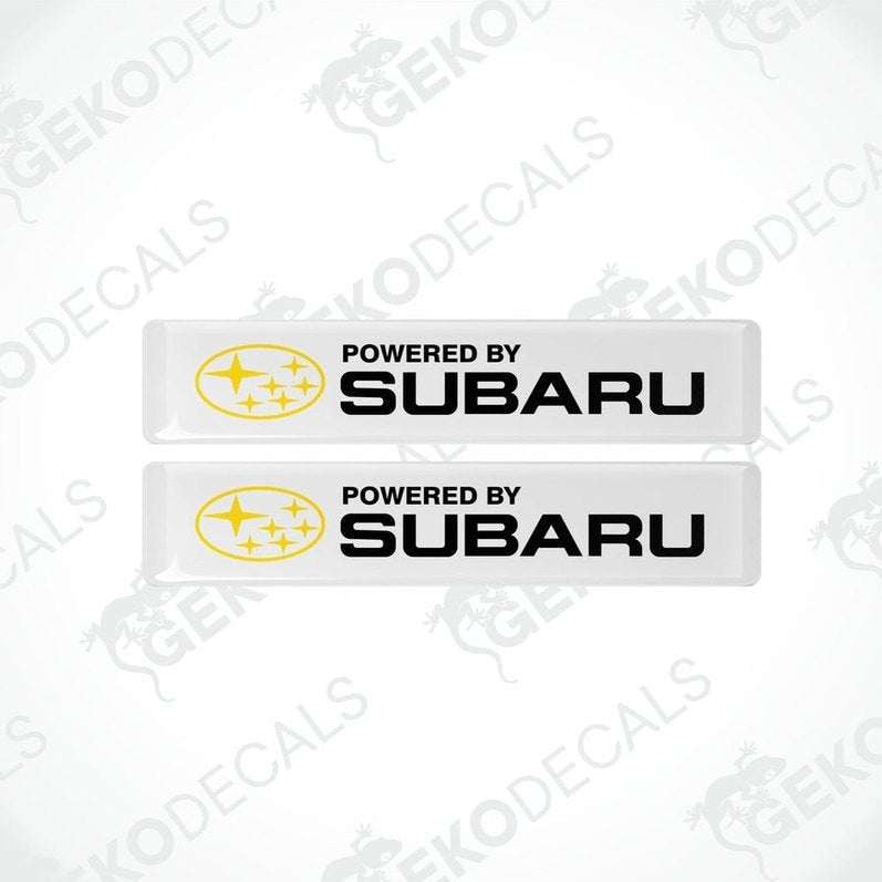 Two withe vinyl stickers with the text 'POWERED BY SUBARU' and the Subaru logo.