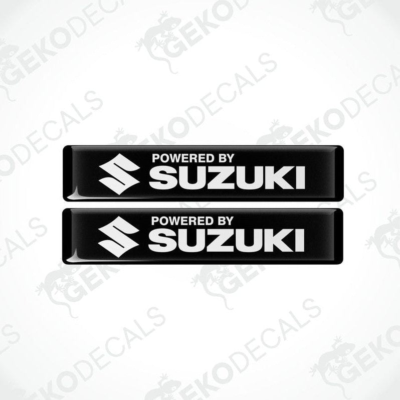 Two black vinyl stickers with the text 'POWERED BY SUZUKI' and the Suzuki logo.