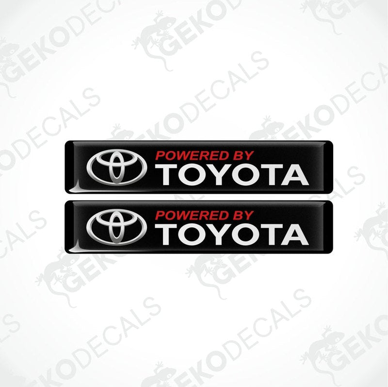 Two black vinyl stickers with the text 'POWERED BY TOYOTA' in red and white Toyota logo.