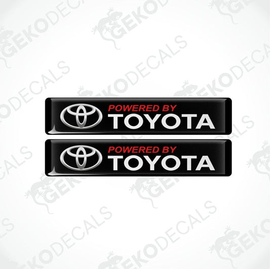 Two black vinyl stickers with the text 'POWERED BY TOYOTA' in red and white Toyota logo.