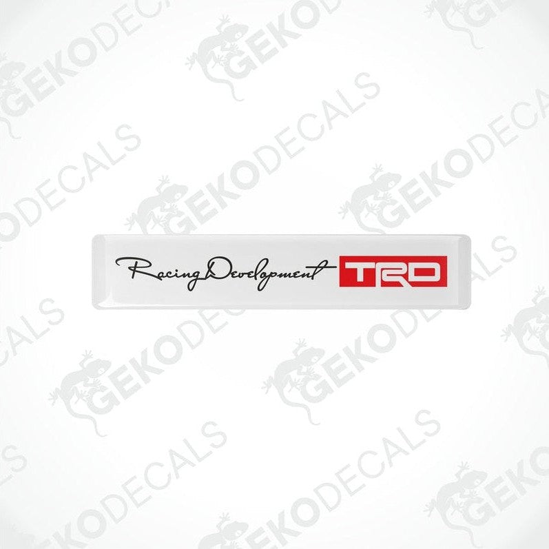  Withe vinyl decals with black and red text and logos, one decal reads 'Racing Development' and the other has 'TRD' logo.