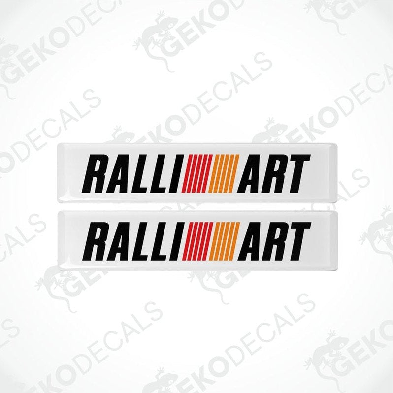 Two rectangular vinyl decals with 'RALLIART' written in black letters and a red and orange stripe design.