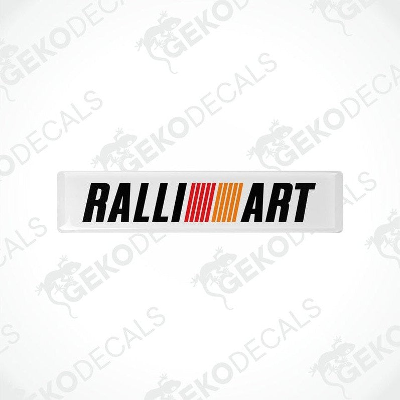 Rectangular vinyl decals with 'RALLIART' written in black letters and a red and orange stripe design.