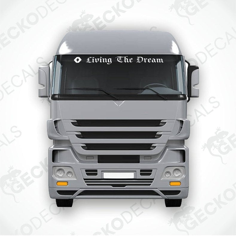 A die cut decal with the phrase 'Living The Dream' positioned on the windscreen of a gray RENAULT truck.