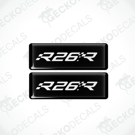 Two black rectangular vinyl decals with 'R26.R' white text on them, intended for use as car stickers.