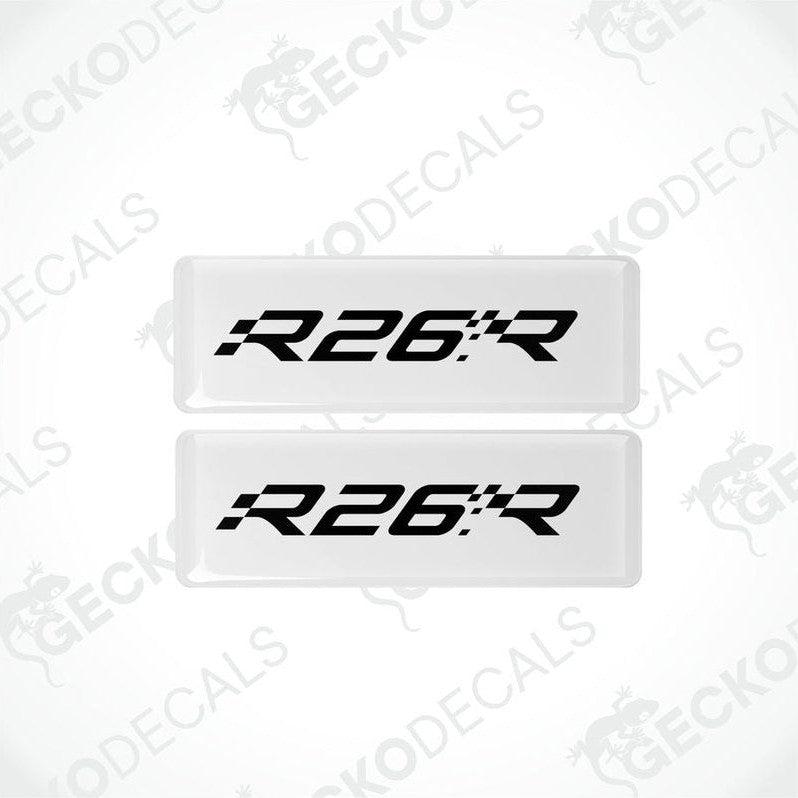 Two withe rectangular vinyl decals with 'R26.R' black text on them, intended for use as car stickers.