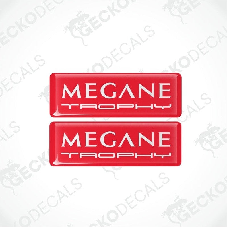 Two red rectangular vinyl decals with 'MEGANE TROPHY'withe text on them, intended for use as car stickers.