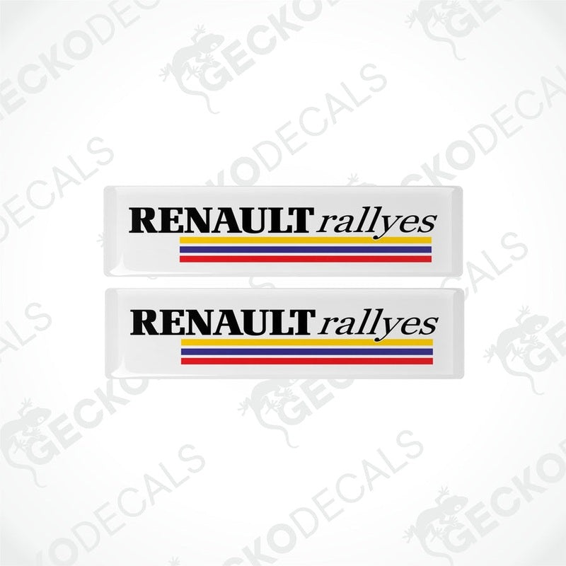 Two withe vinyl stickers with the text 'RENAULT RALLYES' and the Renault logo in red, yellow, and blue.