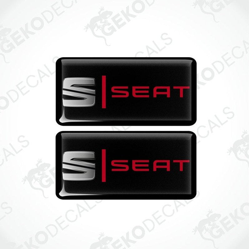 Two black vinyl stickers with the word 'SEAT' in red and white.