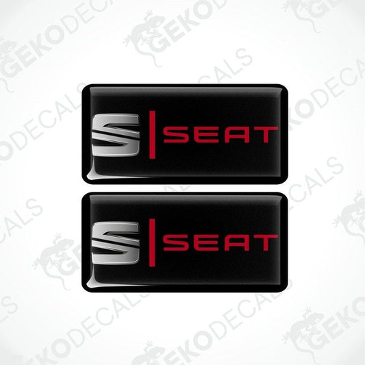 Two black vinyl stickers with the word 'SEAT' in red and white.