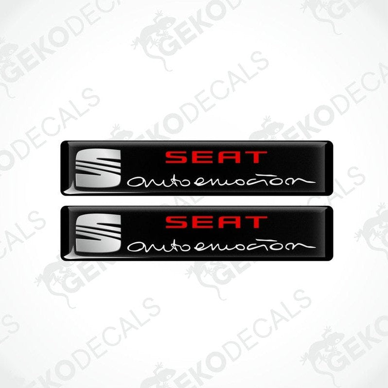 Two black vinyl decals with polyurethane coating featuring the SEAT AUTOEMOUTION logo in withe lettering.