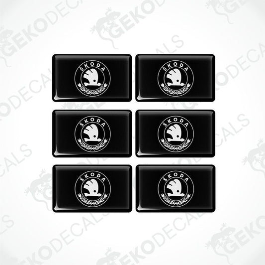 A set of six black vinyl stickers with the Škoda Auto logo in white.