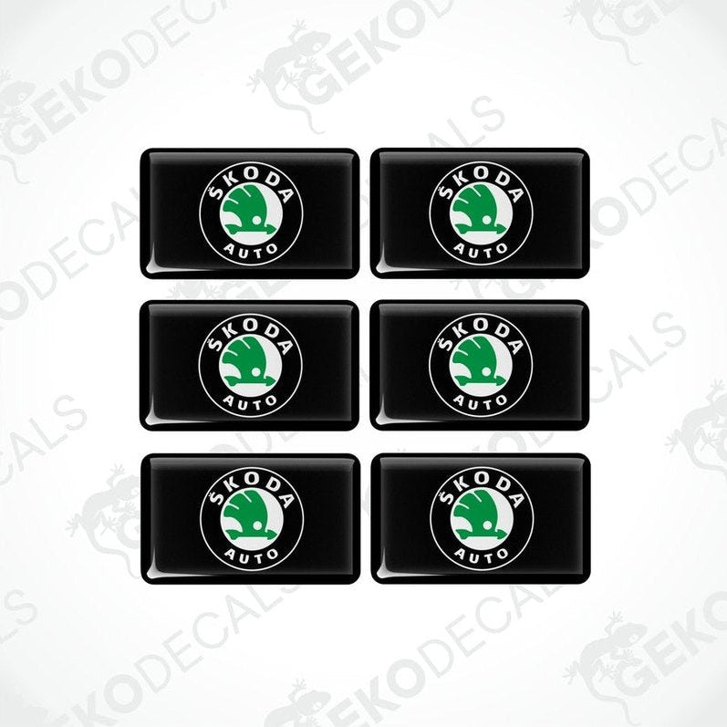 A set of six black vinyl stickers with the Škoda Auto logo in green and white.