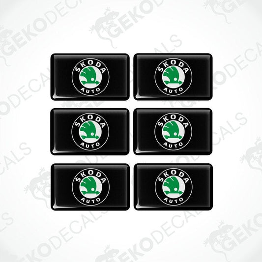 A set of six black vinyl stickers with the Škoda Auto logo in green and white.